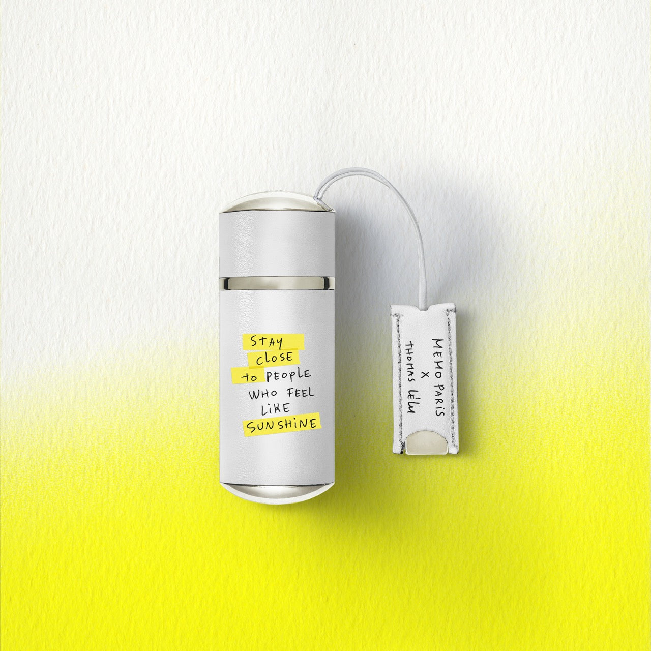 White cylindrical memo paris darling point 10ml travel size perfume bottle with silver cap and yellow handwritten text