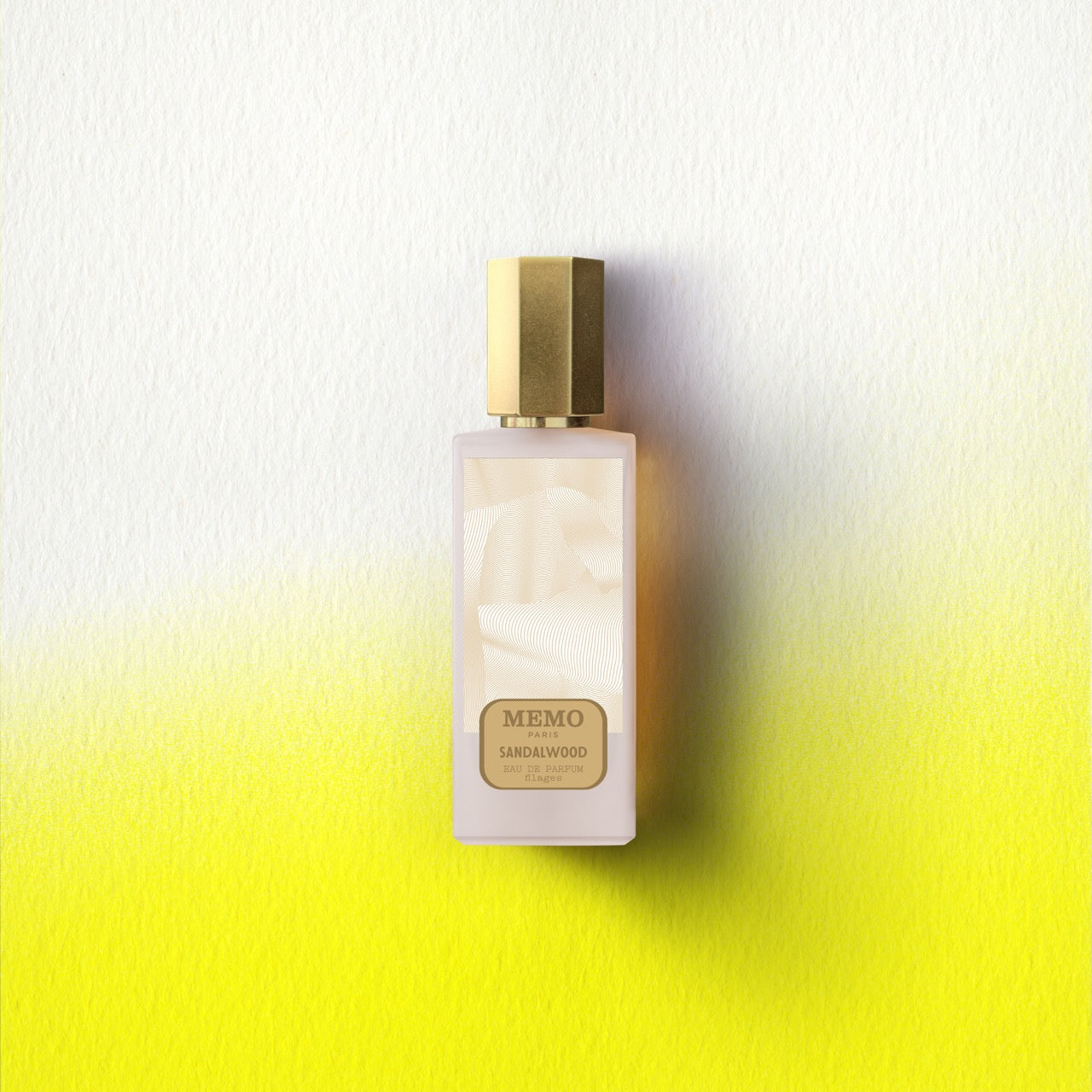 A sleek rectangular memo paris essences filages eau de parfum bottle with frosted glass and polished gold cap