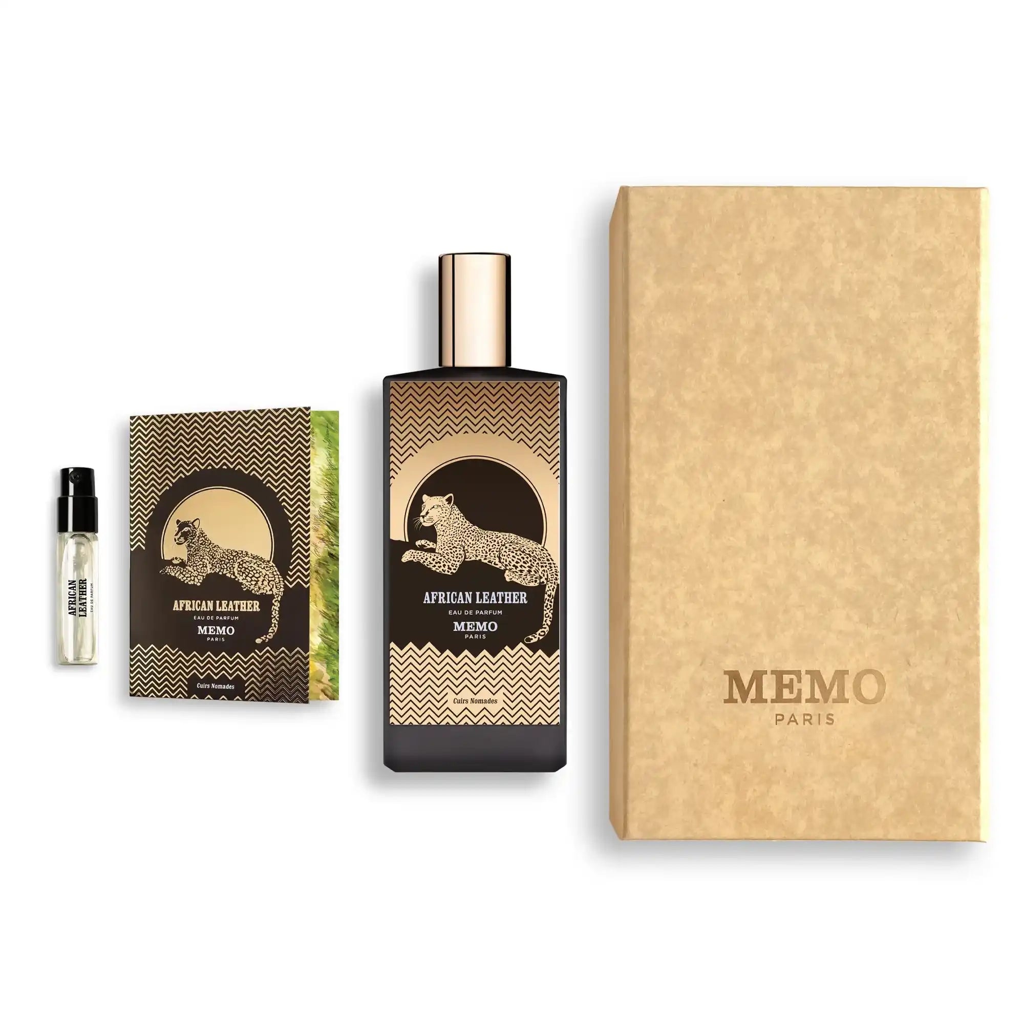 A fragrance set with a black and gold bottle featuring a leopard design, a matching small booklet, and a sample vial, all packaged in a textured beige box.