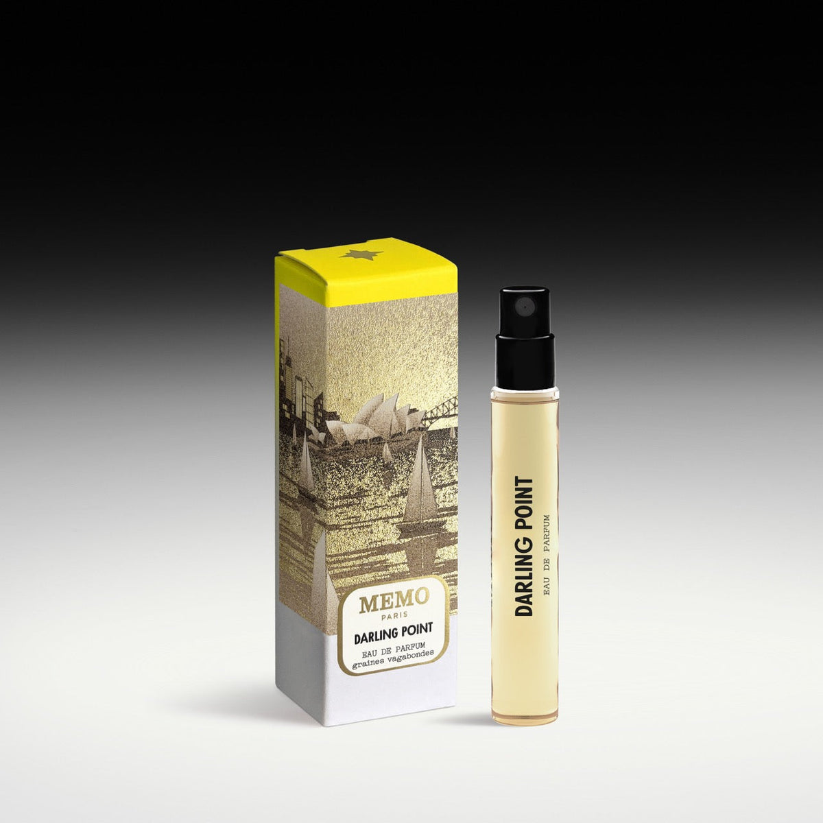 A slender transparent glass bottle of memo paris darling point eau de parfum with pale yellow liquid and black spray nozzle