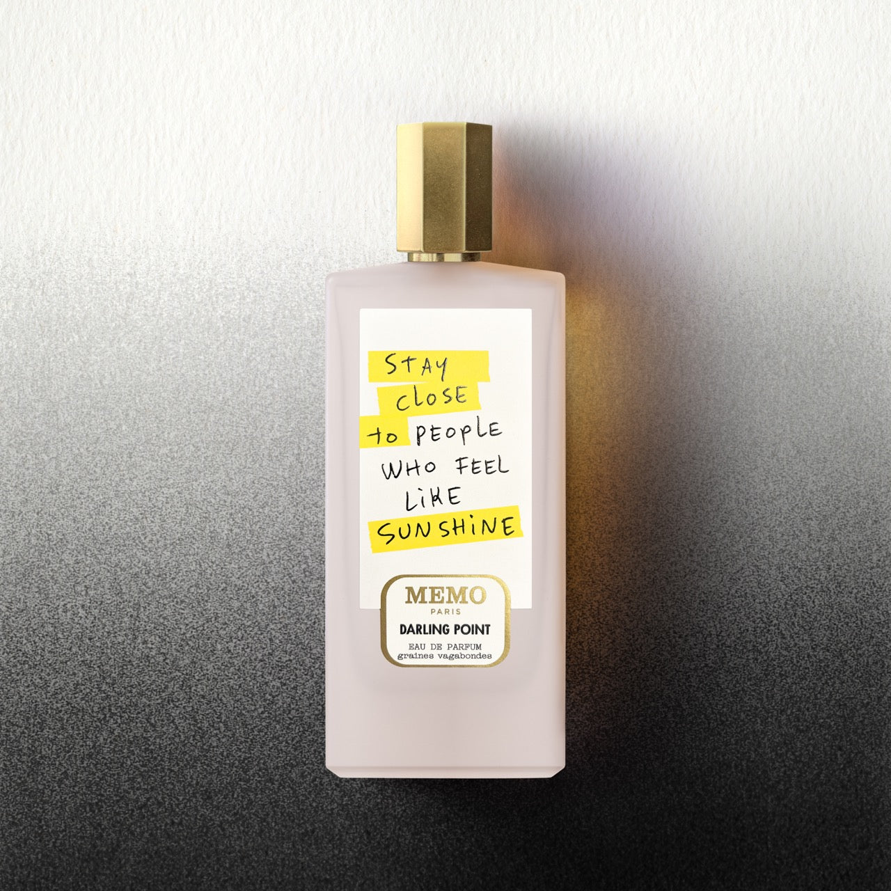 A pale pink rectangular perfume bottle with gold cap and handwritten label from darling point x thomas lelu by memo paris
