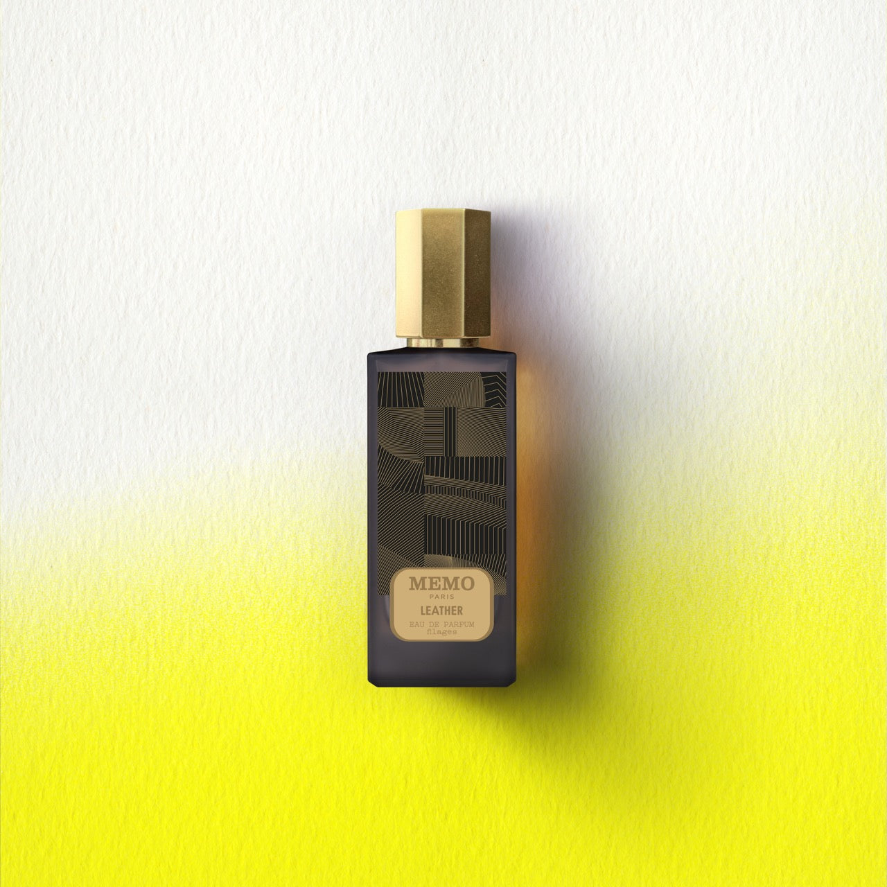 Dark glass bottle with gold cap and geometric line art label for essences filages filages eau by memo paris