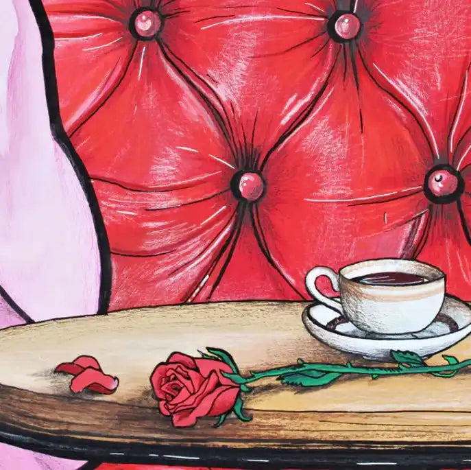 Red tufted armchair with a cup of coffee and a red rose.