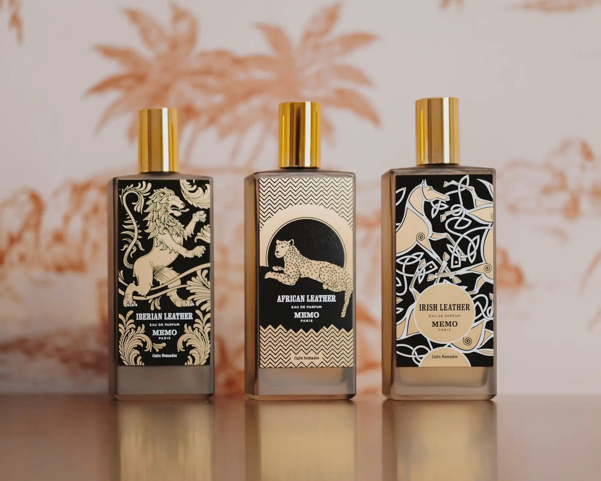 Three distinct bottles of perfume, each featuring unique animal and nature-inspired designs and gold-colored caps.